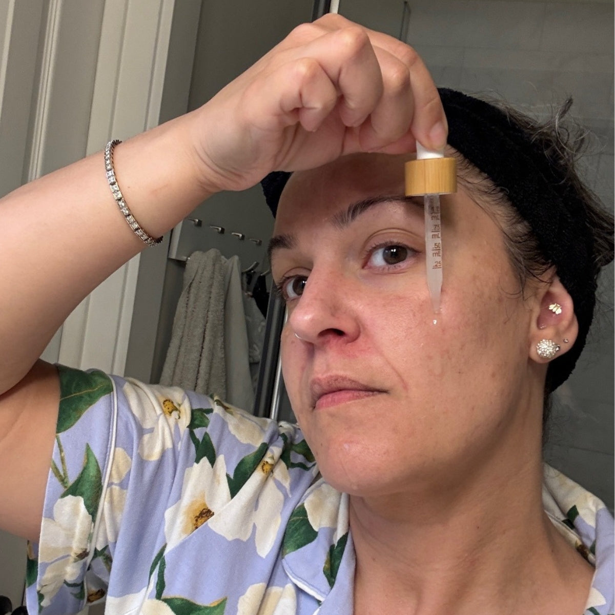 A woman demonstrates the Konenki Complete Serum on her skin.