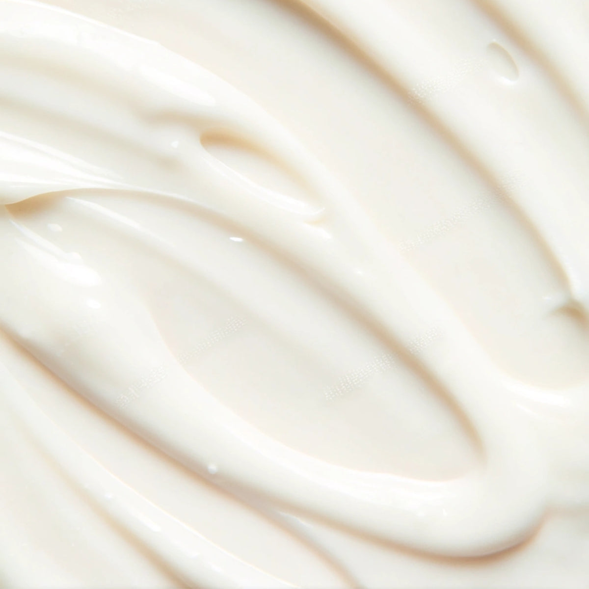 A closeup view of a luxurious, richly textured, cream-coloured moisturizer.